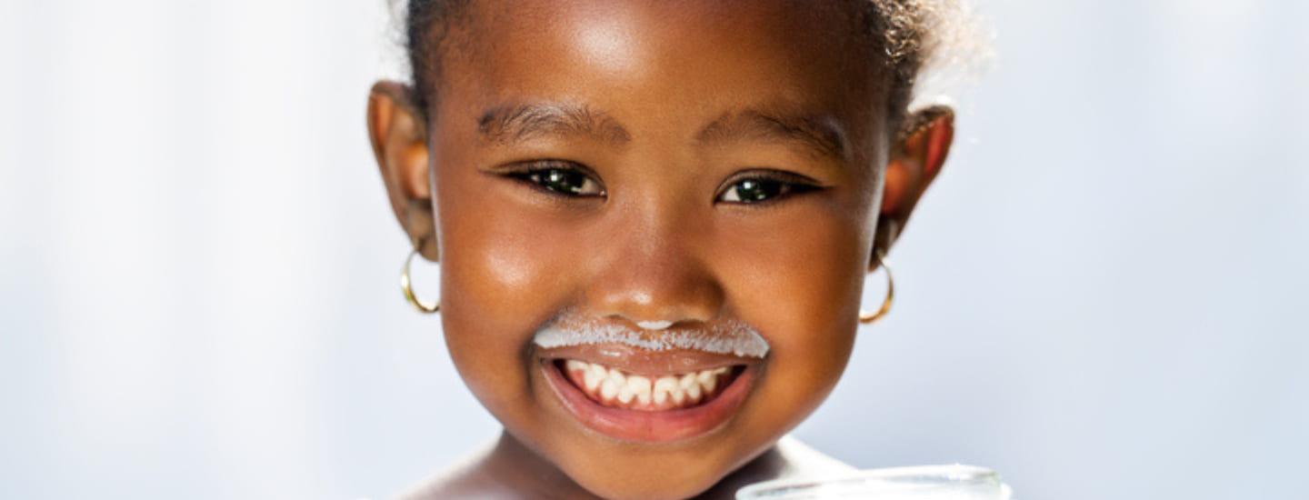 niña sonriendo con bigote de leche
